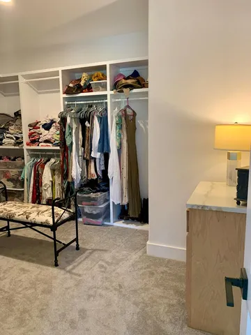a view of walk in closet with clothes