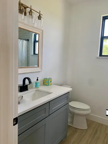 a bathroom with a toilet sink and mirror