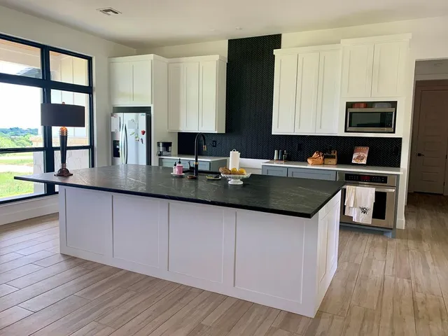 a kitchen with stainless steel appliances granite countertop a sink stove and microwave