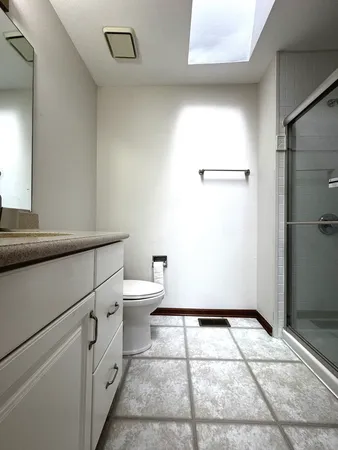 a bathroom with a granite countertop sink toilet and shower