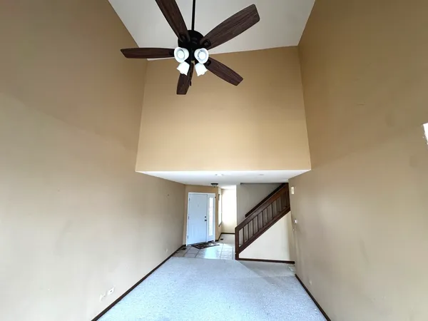 an empty room with a ceiling fan and a fan