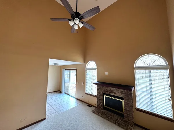 an empty room with a fireplace and windows