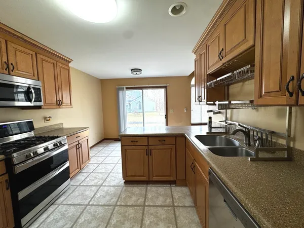 a kitchen with granite countertop a sink stove and cabinets