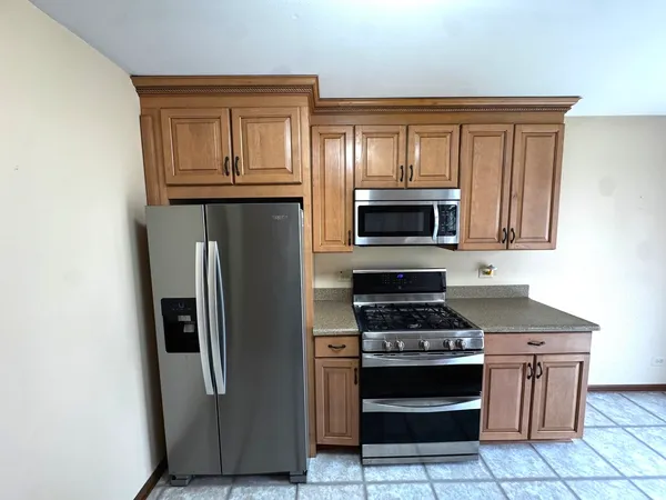 a kitchen with stainless steel appliances granite countertop a stove microwave and refrigerator