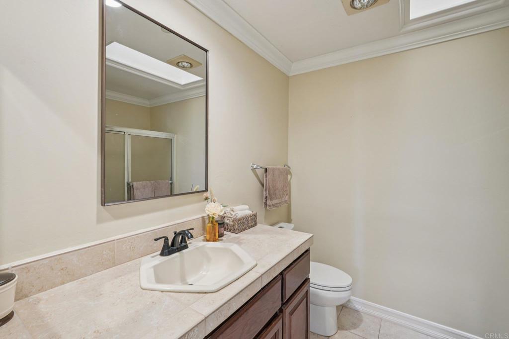 707 Live Oak Park Road South Fallbrook, CA 92028 - Photo 34 of 59 a bathroom with a granite countertop sink a toilet and a mirror