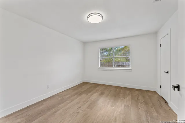 a view of a room with wooden floor and window