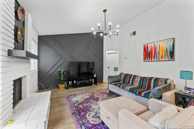 a living room with furniture a flat screen tv and a fireplace