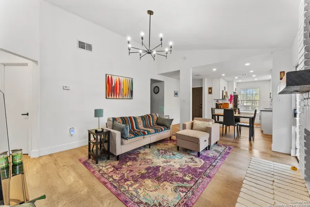 a living room with furniture a dining table and a chandelier