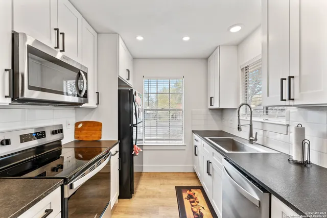 a kitchen with stainless steel appliances a stove sink microwave and cabinets
