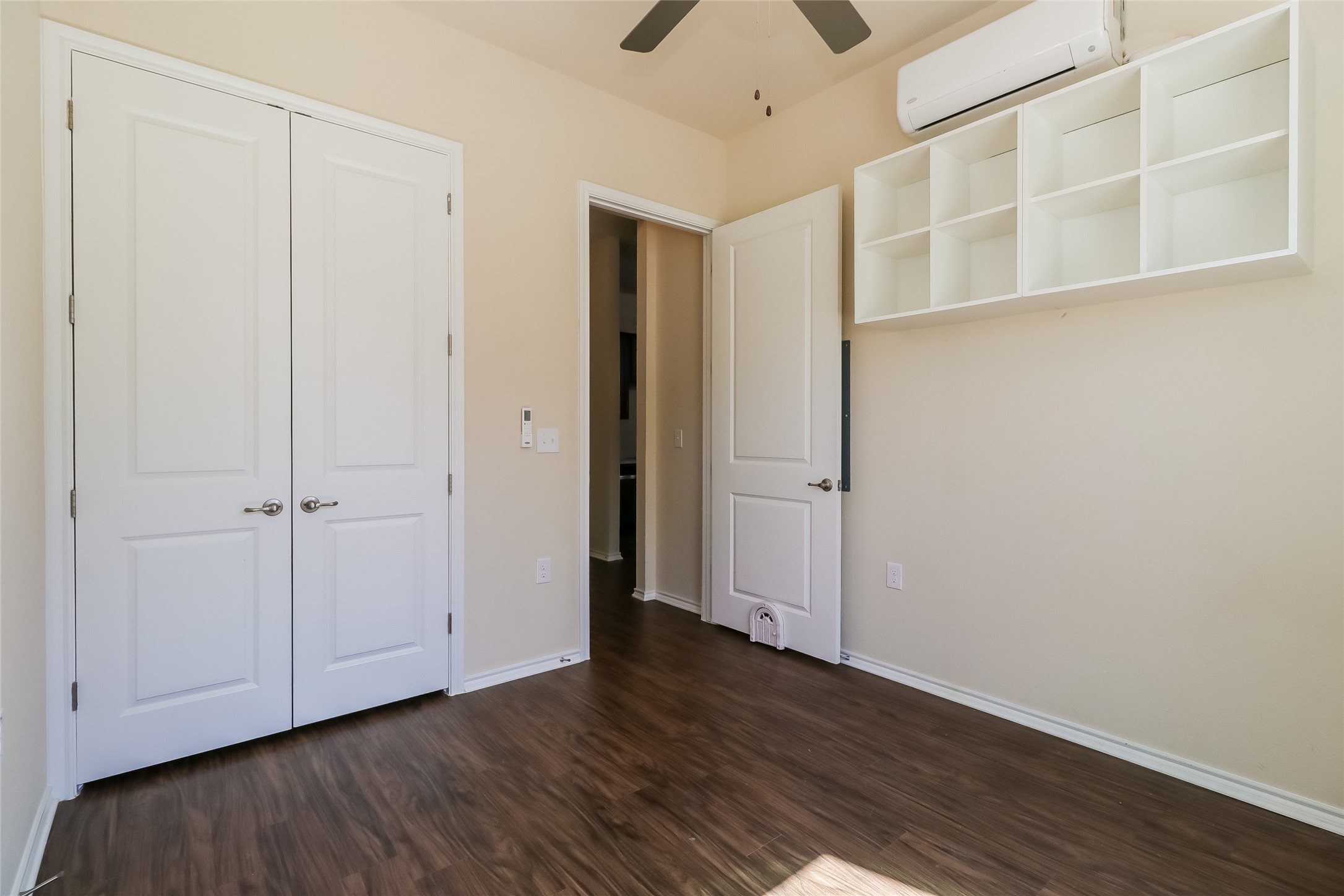 8601 West Gate Boulevard, Unit 7101 Austin, TX 78745 - Photo 13 of 16 Unfurnished bedroom featuring dark wood finished floors, ceiling fan, and a closet