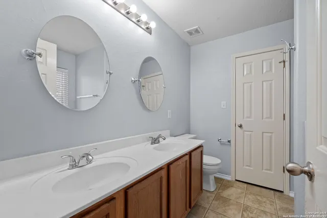 a bathroom with a double vanity sink and a mirror