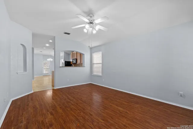 a view of a kitchen with wooden floor and a ceiling fan