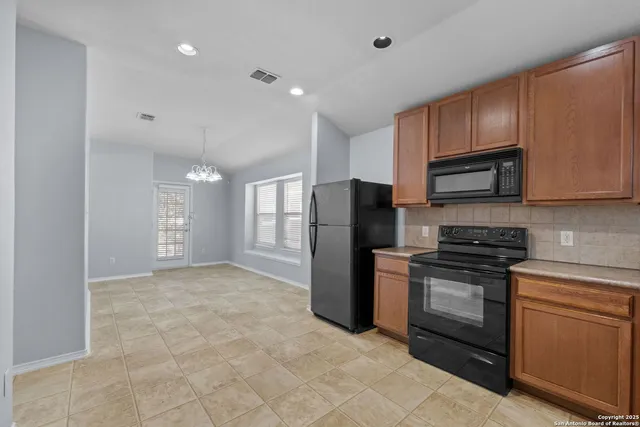 a kitchen with a refrigerator sink and stove top oven