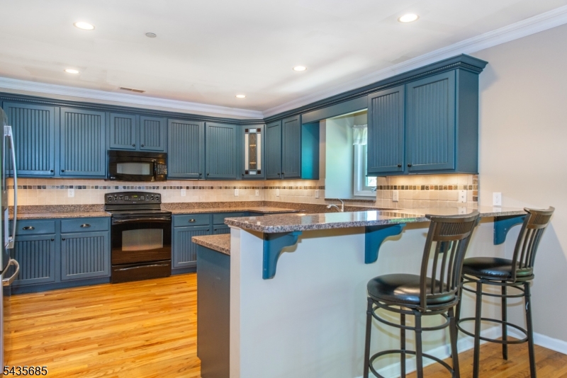 16 Main Street Sparta, NJ 07871 - Photo 4 of 33 a kitchen with granite countertop wooden cabinets a stove top oven a granite counter space and a center island
