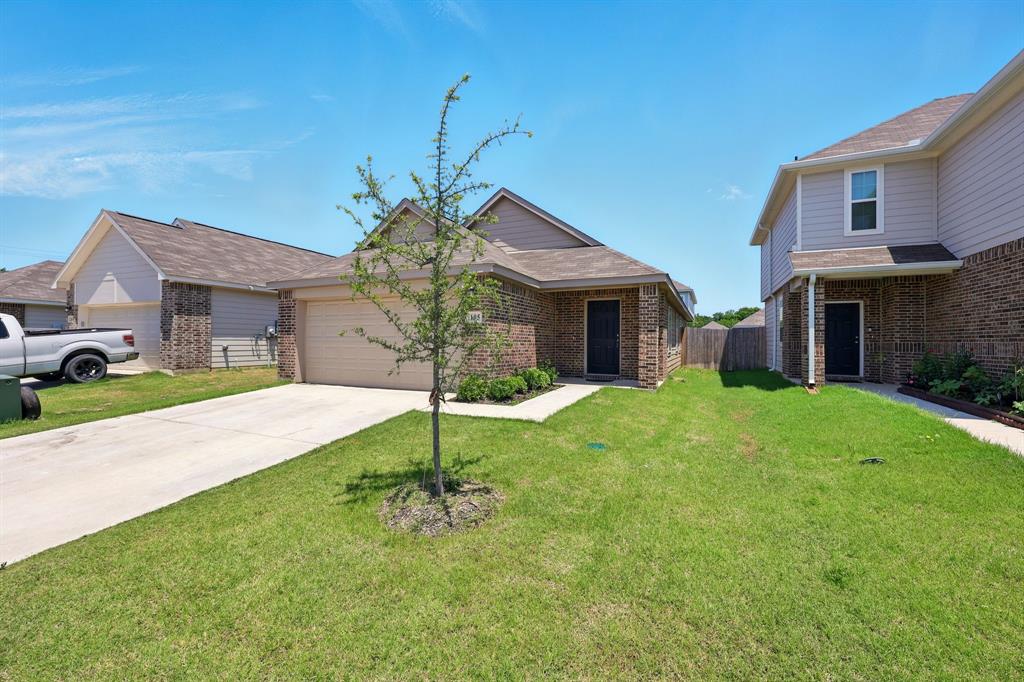 105 Musgrove Road Everman, TX 76140 - Photo 3 of 6 View of front facade with a garage, a front yard, brick siding, and driveway
