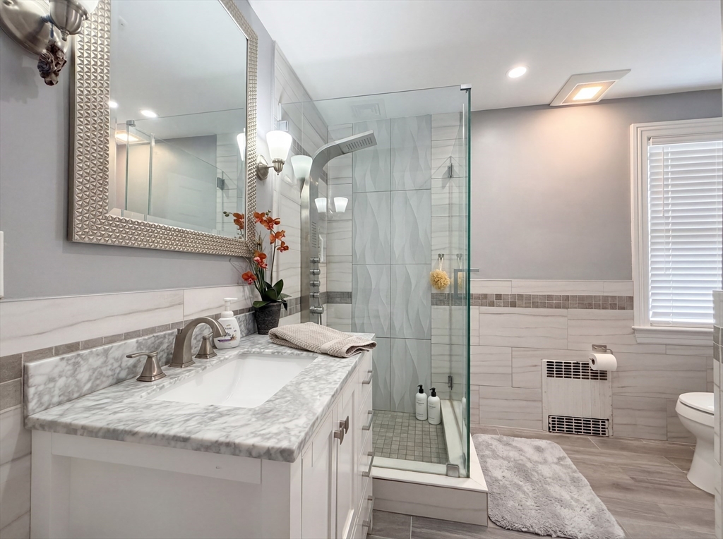 115 Hawthorn Road Braintree, MA 02184 - Photo 25 of 37 a bathroom with a granite countertop sink a toilet a mirror and shower