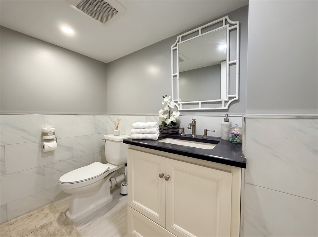 115 Hawthorn Road Braintree, MA 02184 - Photo 32 of 37 a bathroom with a granite countertop sink a toilet and a mirror