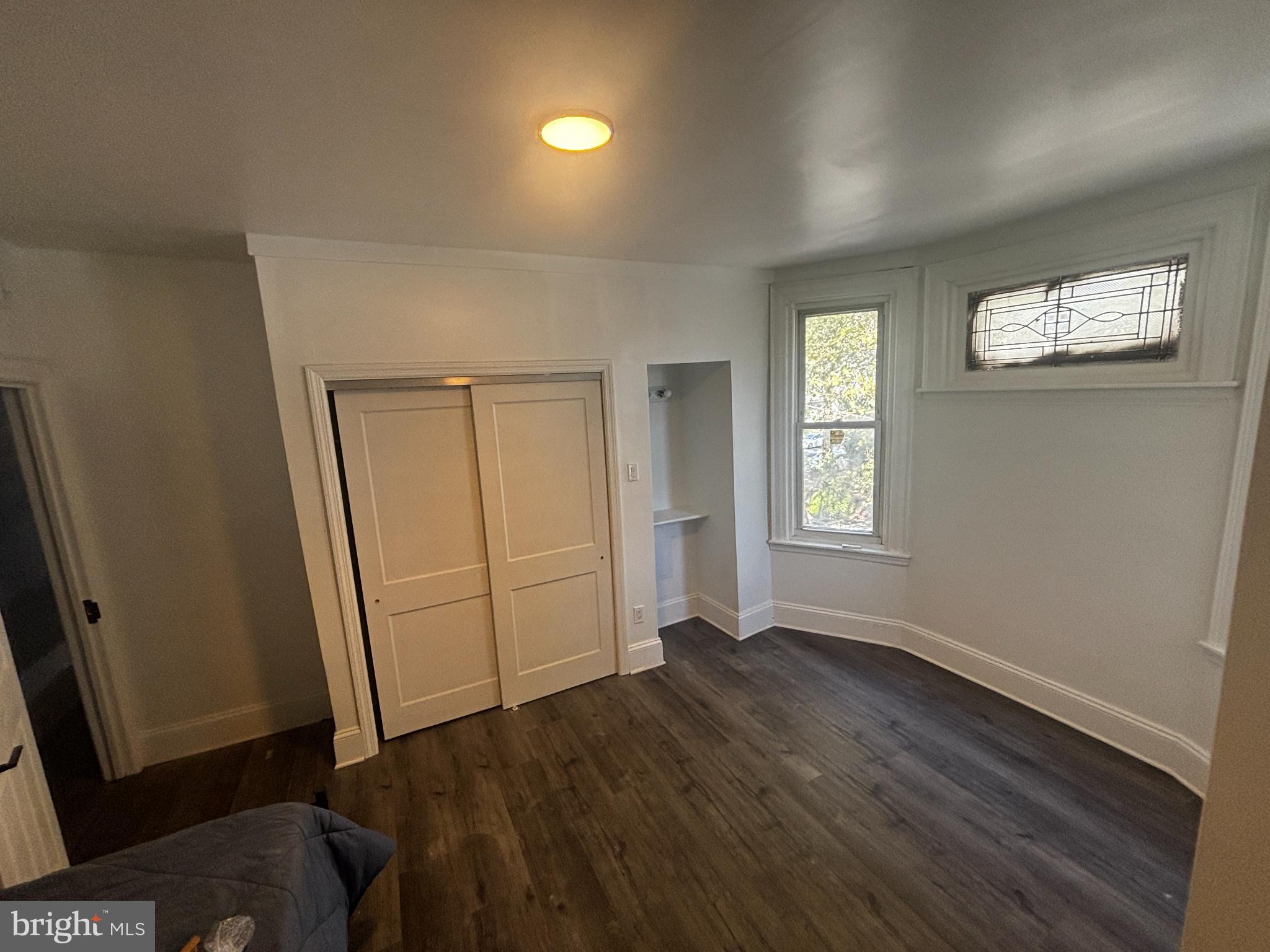 901 South 60th Street Philadelphia, PA 19143 - Photo 23 of 34 an empty room with wooden floor and windows