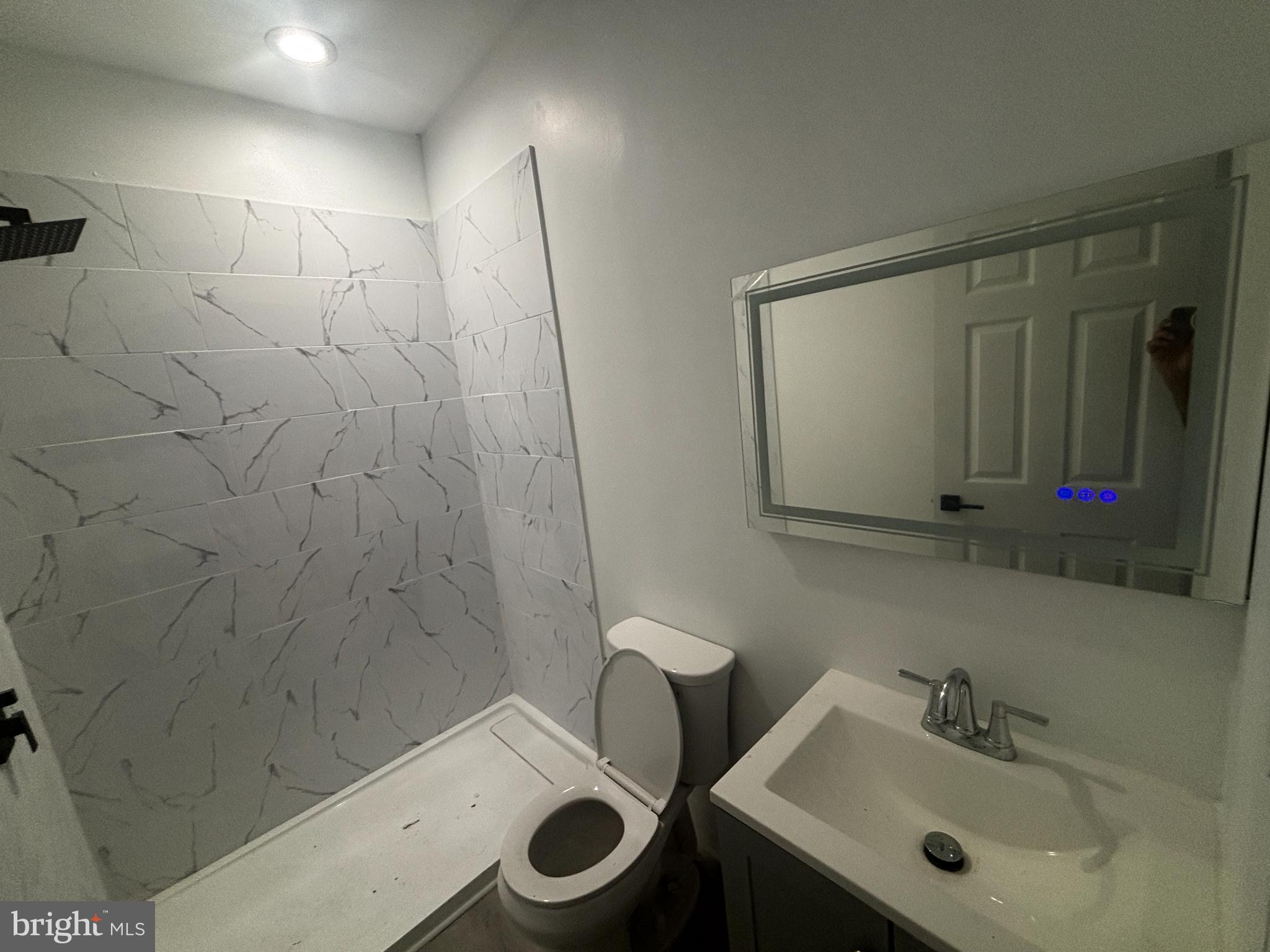 901 South 60th Street Philadelphia, PA 19143 - Photo 25 of 34 a bathroom with a sink mirror and toilet