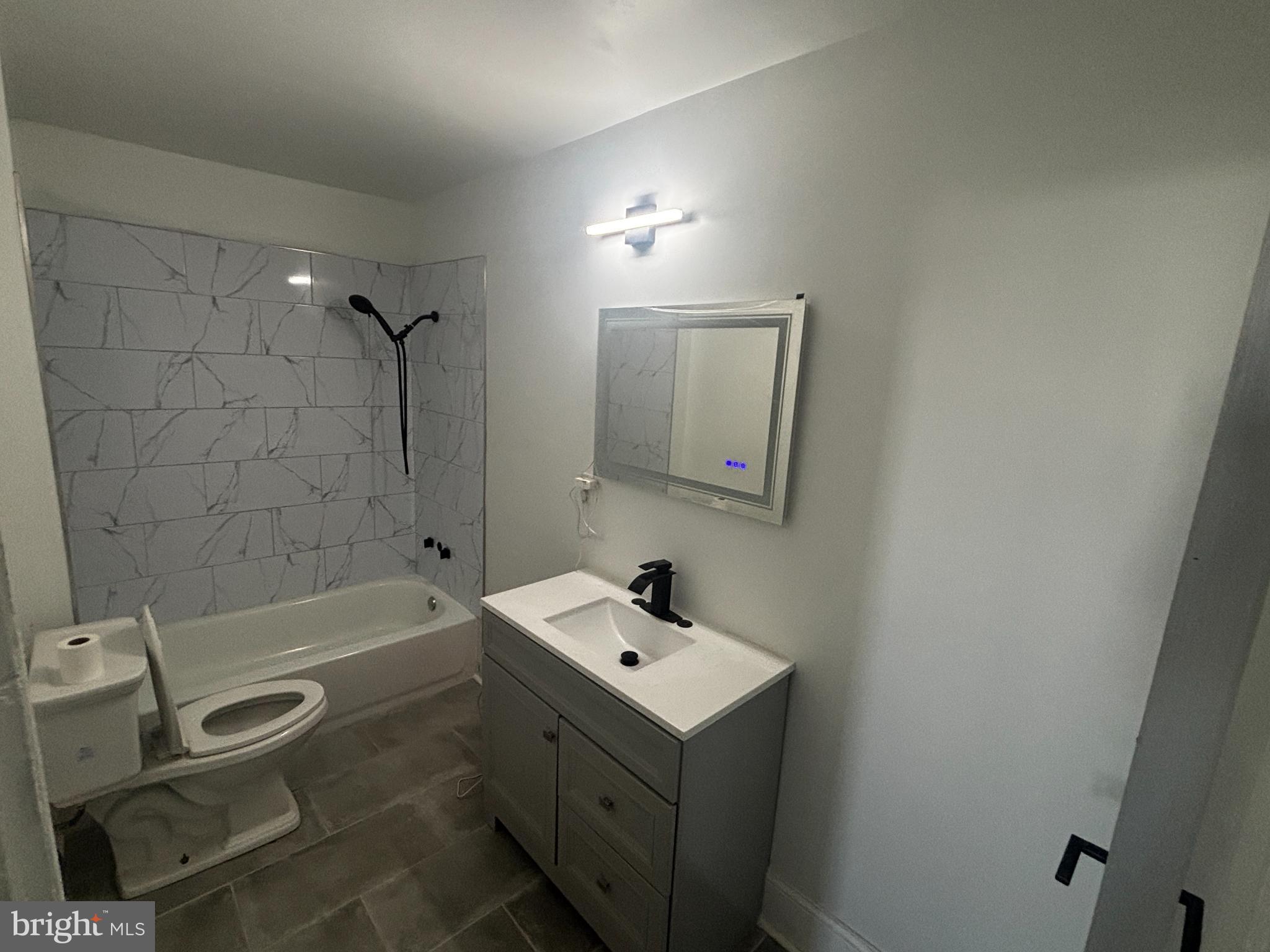 901 South 60th Street Philadelphia, PA 19143 - Photo 26 of 34 a bathroom with a sink mirror vanity and bathtub