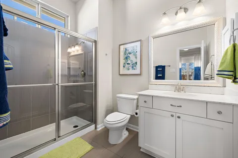 a bathroom with a toilet a sink and glass door