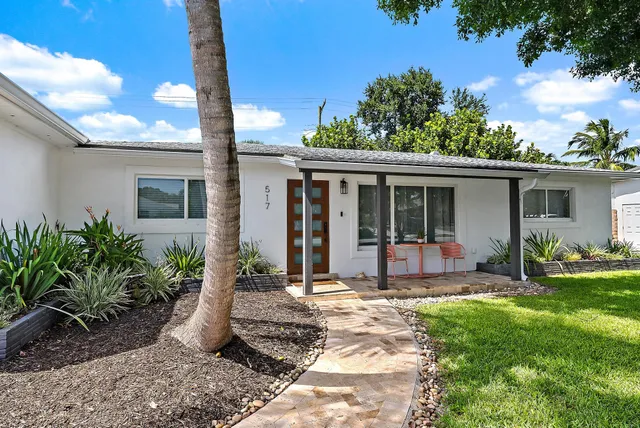 a front view of a house with yard patio and green space