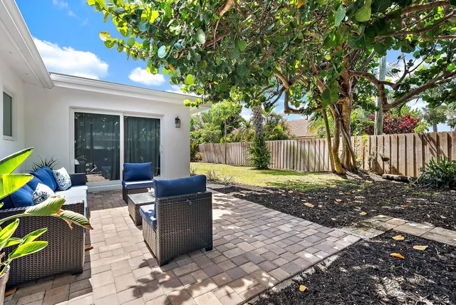 a view of a chair and table in backyard of the house