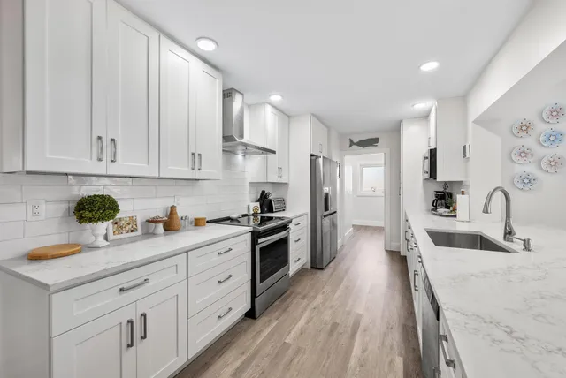 a kitchen with white cabinets and stainless steel appliances