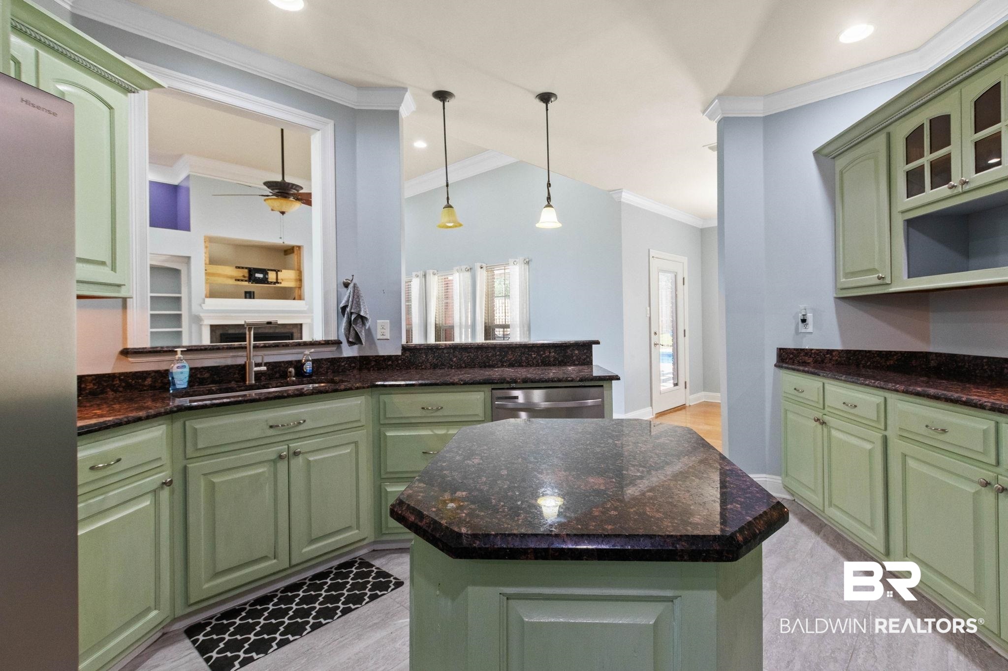 79 Whitetail Run Chatom, AL 36518 - Photo 27 of 82 Kitchen featuring green cabinetry, dark speckled countertops, a center island with additional counter space, stainless steel appliances, and a pass-through window to the living area