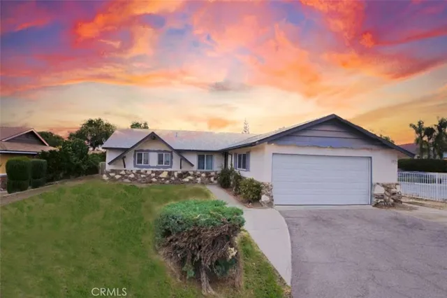 a view of a house with a yard and potted plants