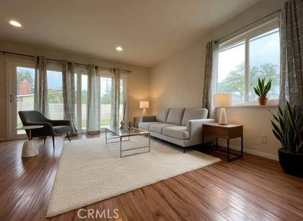a view of a big room with wooden floor and a kitchen