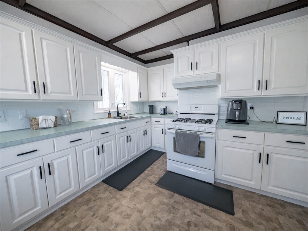 10 Guild Road Saugus, MA 01906 - Photo 11 of 32 a kitchen with granite countertop white cabinets white stainless steel appliances with a sink and dishwasher