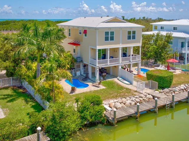 an aerial view of a house with swimming pool and a yard