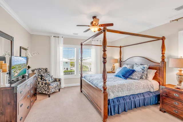 a bedroom with bed and a flat tv screen on the dresser