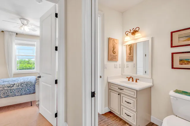 a bathroom with a sink toilet vanity and window