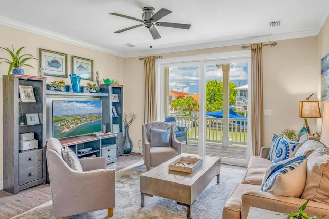 a living room with furniture a ceiling fan a flat screen tv and a window