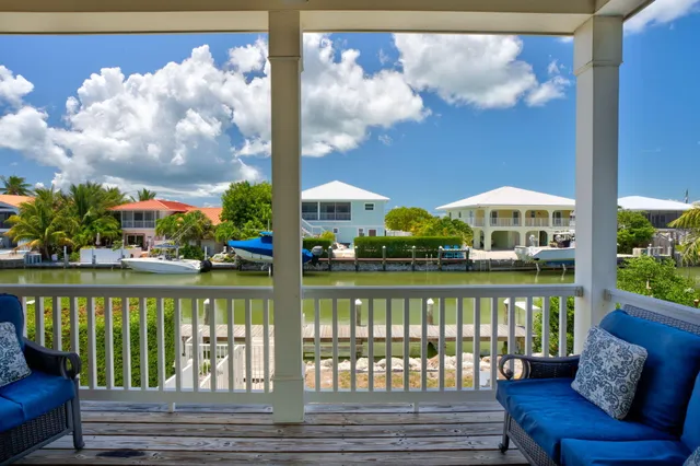 a view of a lake from a balcony with furniture