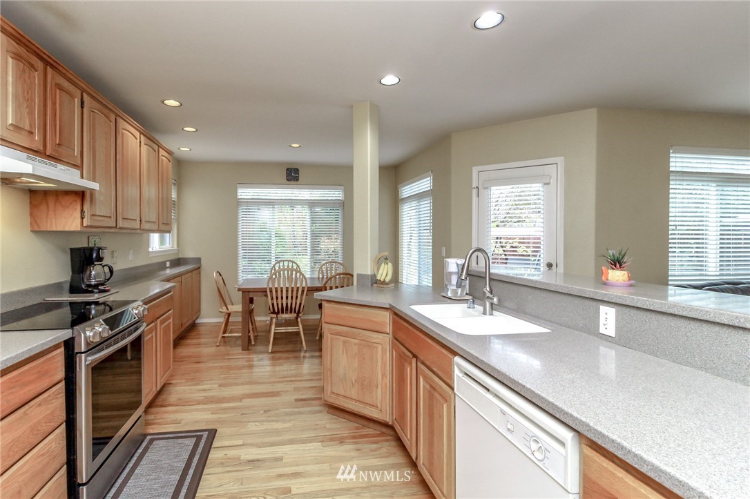 18547 173rd Way Southeast Renton, WA 98058 - Photo 12 of 27 a large kitchen with stainless steel appliances granite countertop a lot of counter space and a sink
