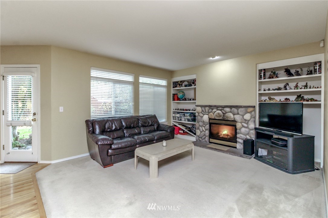 18547 173rd Way Southeast Renton, WA 98058 - Photo 8 of 27 a living room with furniture a flat screen tv and a fireplace