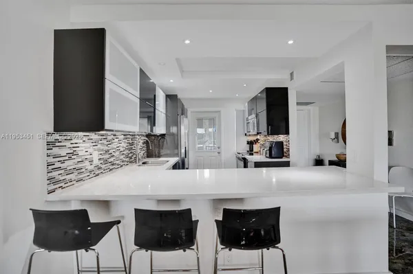 a kitchen with stainless steel appliances kitchen island granite countertop a table and chairs in it