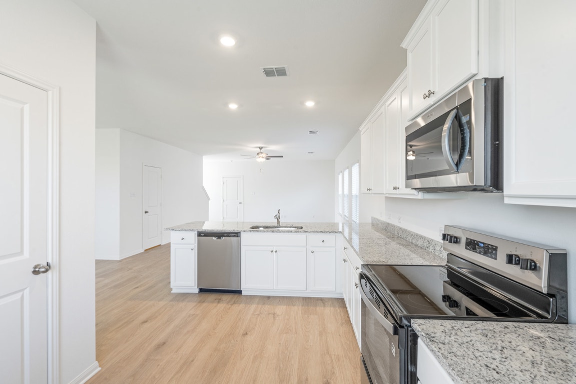 120 Paria Court Jarrell, TX 76537 - Photo 4 of 8 a kitchen with a stove sink and cabinets