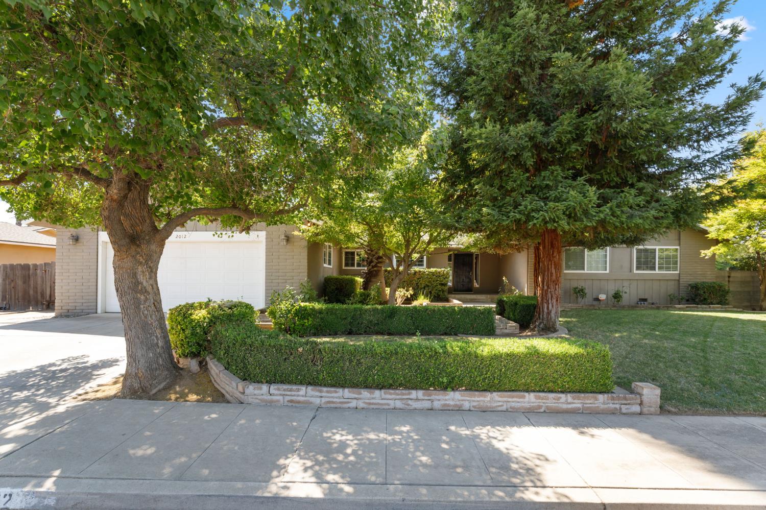 2012 Beverly Avenue Clovis, CA 93611 - Photo 2 of 42 a front view of a house with a yard and a garage
