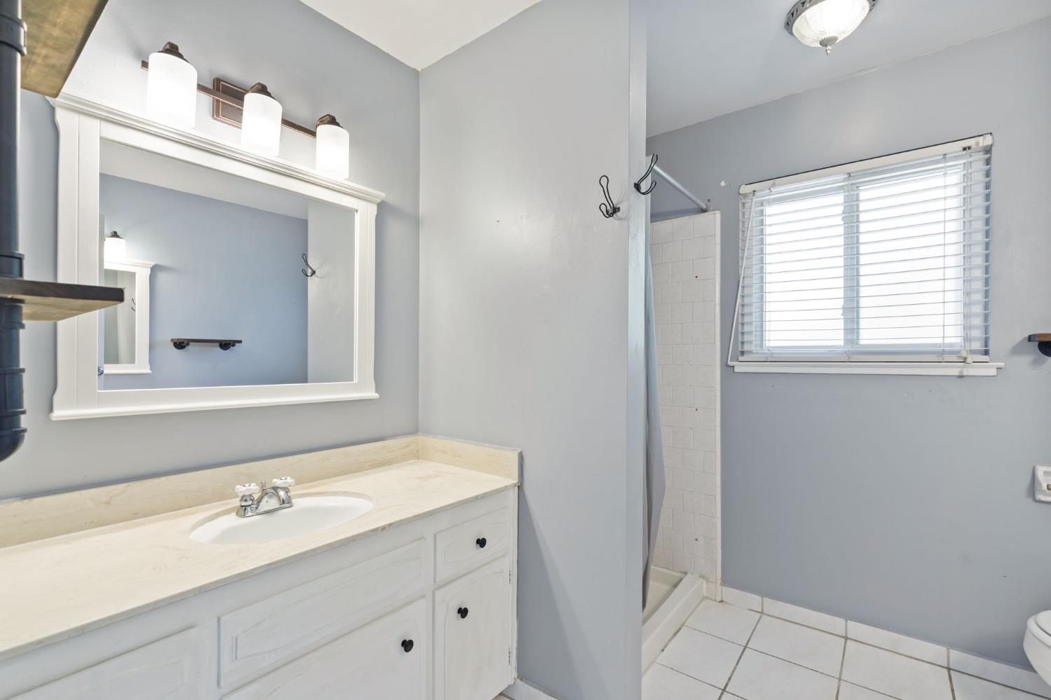 2012 Beverly Avenue Clovis, CA 93611 - Photo 10 of 42 a bathroom with a sink a vanity and a mirror