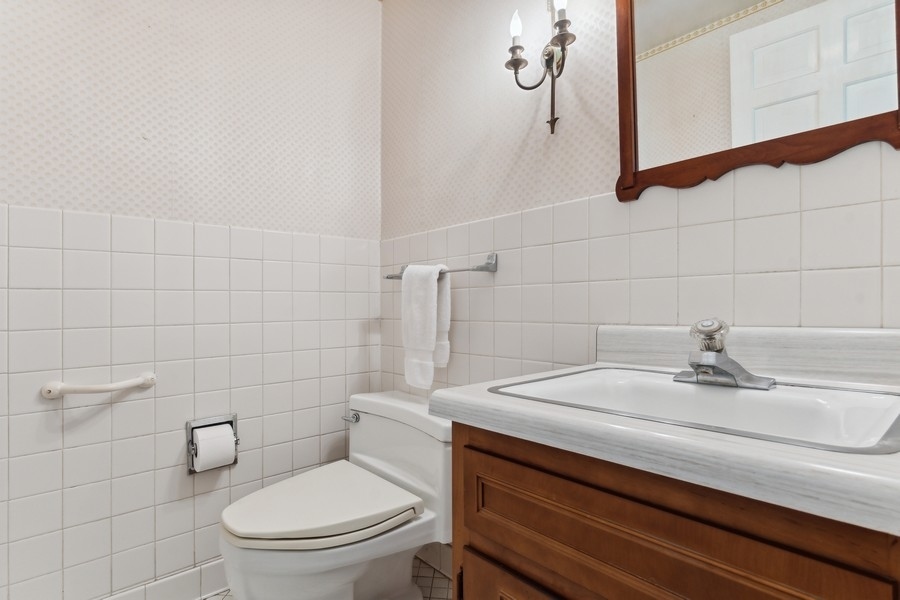 180 Wagner Road Northfield, IL 60093 - Photo 12 of 22 a bathroom with a sink a toilet and mirror