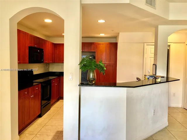 a kitchen with sink a refrigerator and microwave