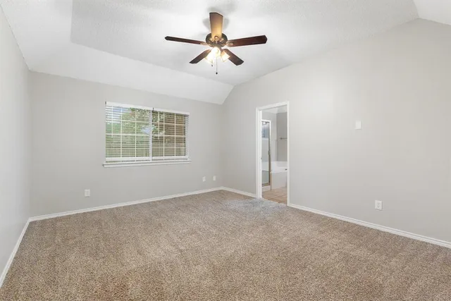an empty room with windows and ceiling fan