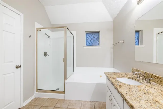 a bathroom with a granite countertop sink a mirror and a shower