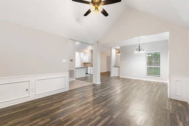a view of empty room with wooden floor and windows