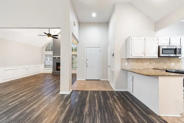 a view of a kitchen with wooden floor and electronic appliances