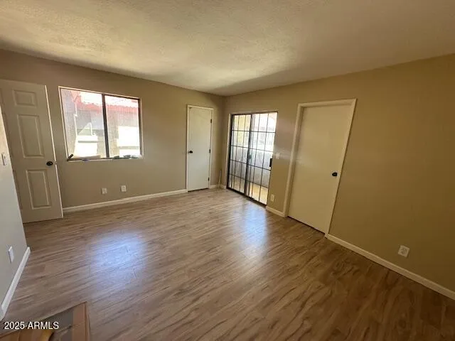 an empty room with wooden floor and windows